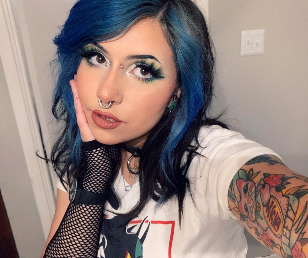 Model with Atlantic Blue Hair Color - Woman with blue ombré hair, bold makeup, piercings, and tattoos showcasing Punky Colour dye results.