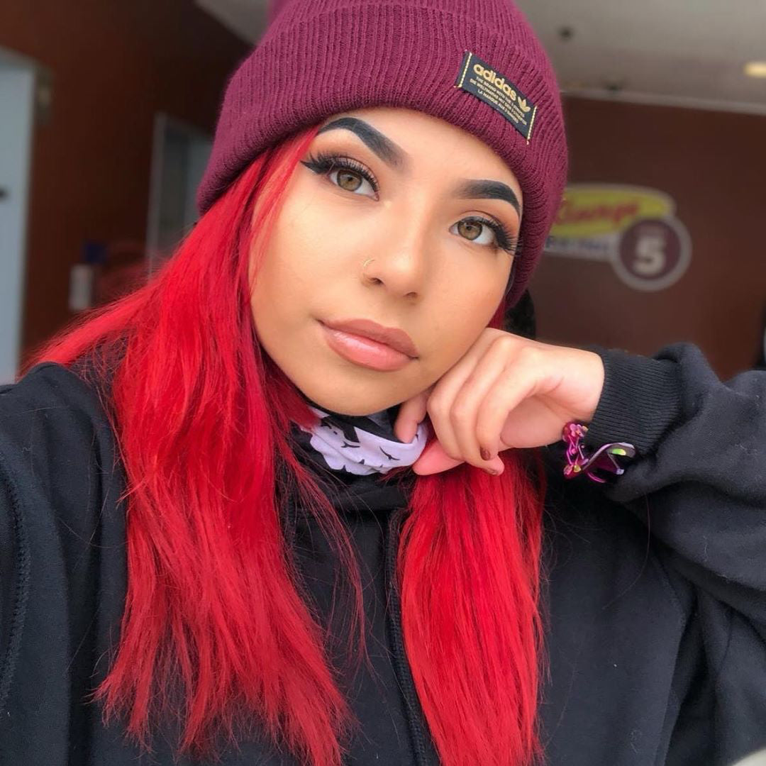 Model with Straight Cherry Red Hair – Woman with sleek cherry red hair under a beanie, dyed with Punky Colour for bold vibrancy.