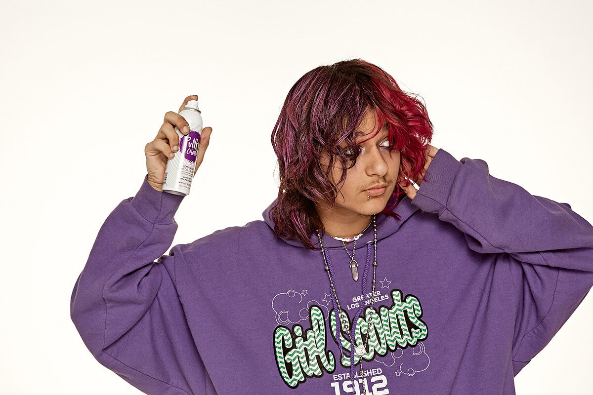 Punky Colour Panther Purple hair spray application – A model in a purple hoodie applying Panther Purple temporary hair spray for a bold color refresh.