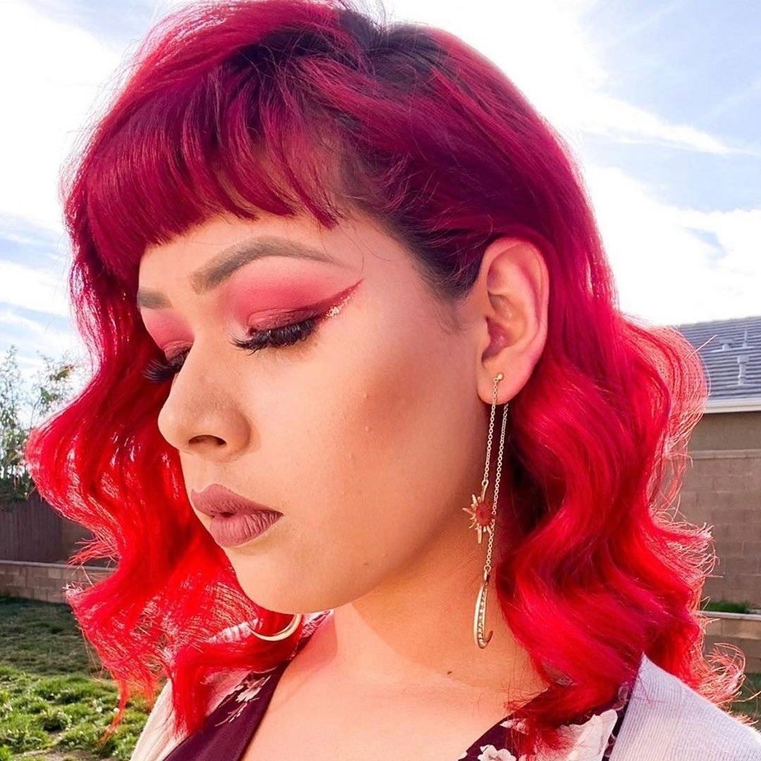 Punky Colour Red Wine hair on model – A woman with striking red curls, styled in a bold, fiery hue using Punky Colour hair dye.