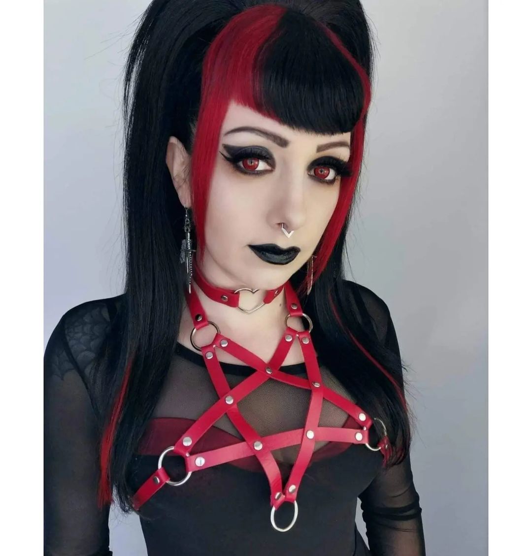 Gothic woman with black and red hair – A gothic-inspired woman with bold black and red hair, wearing dark makeup and edgy accessories.